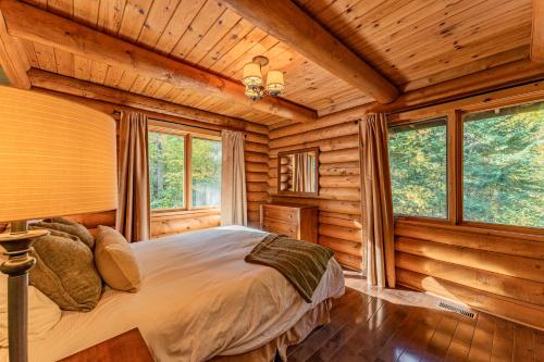 een slaapkamer met een bed in een blokhut bij Private A-Frame Log Cabin near Tremblant With Hot tub Game Room in Labelle