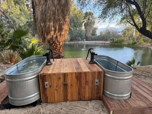 a hot tub and a wooden box next to a pond at Reserve The Entire Ranch up to 28 guests in Desert Hot Springs
