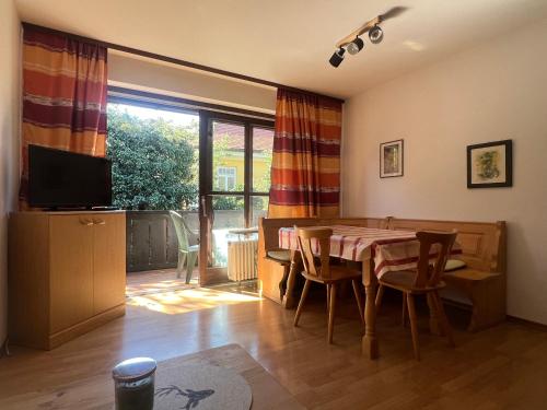 a dining room with a table and chairs and a television at ciao-aschau FeWo Fey in Aschau