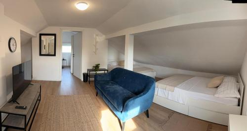 a bedroom with a bed and a blue chair at Family House Roza in Gračec