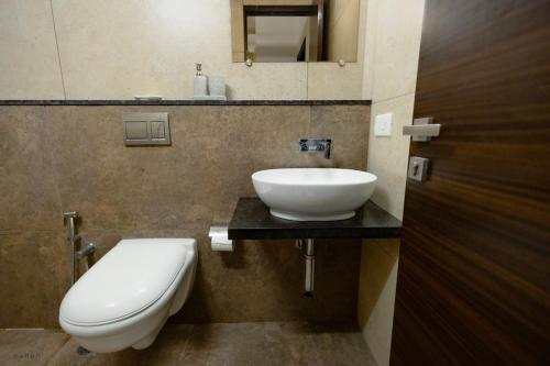 a bathroom with a white sink and a toilet at Modern 1BHK by Kastra Homes, Siolim in Cunchelim