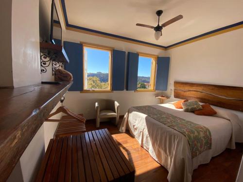 une chambre avec un lit et un banc dans l'établissement Pousada Relíquias do Tempo, à Diamantina