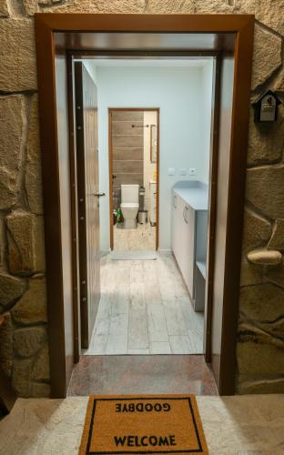 a doorway into a bathroom with a toilet and a sink at Апартамент Милена in Smolyan
