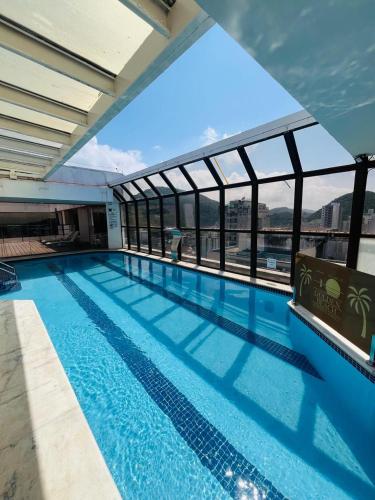 Guarujá Golden Beach 158 - Conforto com Piscina Climatizada في غوارويا: مسبح فوق مبنى