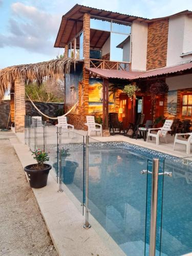 uma casa com piscina na frente de uma casa em Cabaña Sol y Mar em San Antero