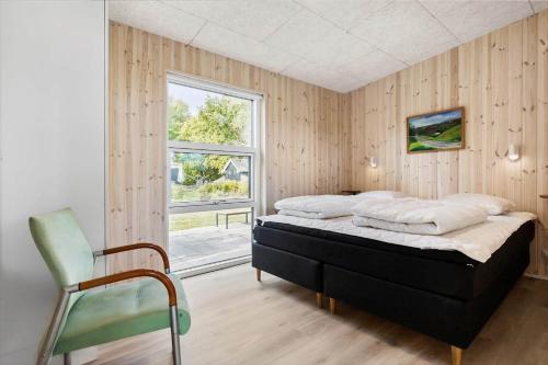 una camera da letto con un letto, una sedia e una finestra di 8959-Orsted-Klydevej-9 a Estruplund