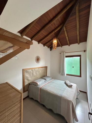 a bedroom with a bed and a large window at Casa Luminah in Itacaré