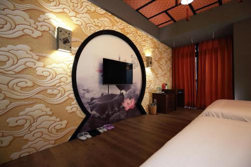 a bedroom with a mirror and a tv on a wall at Buckingham Palace B&B in Beipu