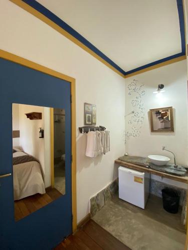 a room with a bathroom with a sink and a bed at Pousada Relíquias do Tempo in Diamantina