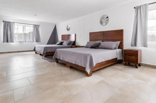 a bedroom with two beds and a tile floor at Pedernal Hotel in San Miguel de Allende