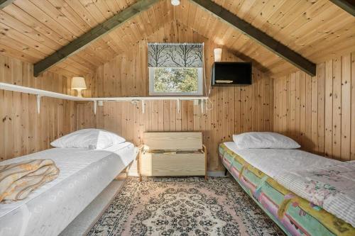 Ce lit se trouve dans un dortoir doté de murs en bois et d'une fenêtre. dans l'établissement N336-Karrebaeksminde-Cypresvaenget-69, à Enø By