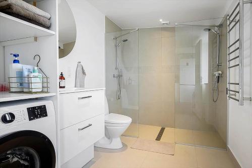 a white bathroom with a shower and a toilet at N337-Karrebaeksminde-Strandrylevej-11 in Enø By