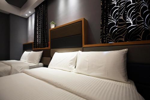 a bedroom with two beds with white pillows at Buckingham Palace B&B in Beipu