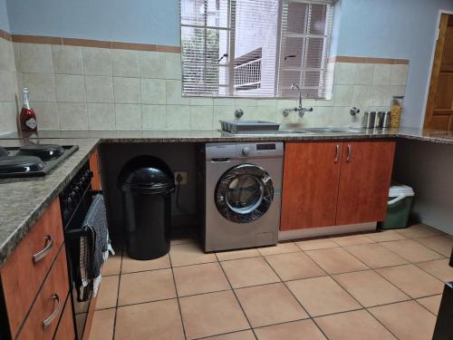una cocina con lavadora y fregadero en Mandy & Mos' Holiday Townhouse, en Four Ways