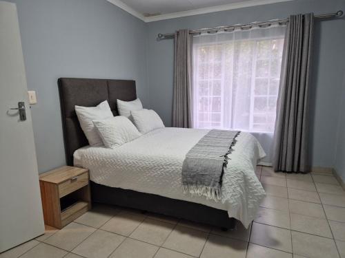 1 cama en una habitación con ventana y visores de cama en Mandy & Mos' Holiday Townhouse, en Four Ways