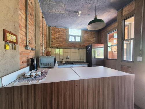 a kitchen with a large white island in the middle at SHB - Chácara Koxixo, Piscina, Refúgio Urbano e Conforto in Presidente Prudente