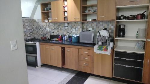 Una cocina con gabinetes de madera y un horno de estufa. en Apartamento em Adrianópolis confortável, en Manaus