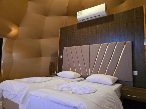 a bedroom with two beds with white sheets and pillows at WADI RUM GUlDE , CAMP & TOUR in Wadi Rum