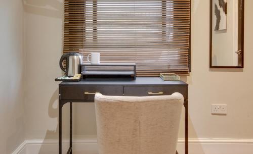 a desk with a toaster and a telephone on it at City Centre GuestHouse By Luxiety Stays Cambridge Perfect For Families With Affordable Rates in Cambridge