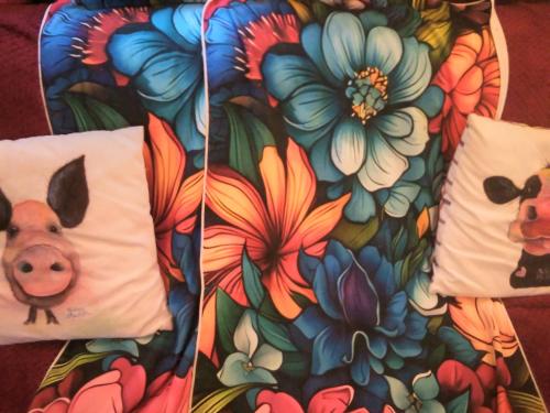 リンカーンにあるSmall Rosie River Glamping Pod for 2の豚と花の絵が描かれた枕2つ