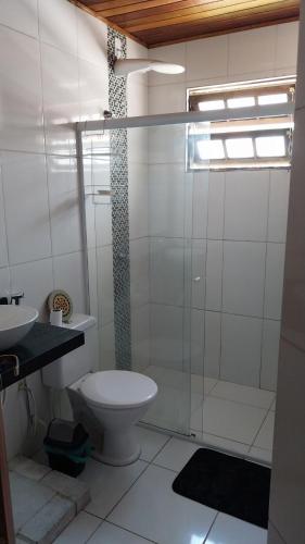 a bathroom with a toilet and a glass shower at Sobrado entrada de Paraty in Paraty