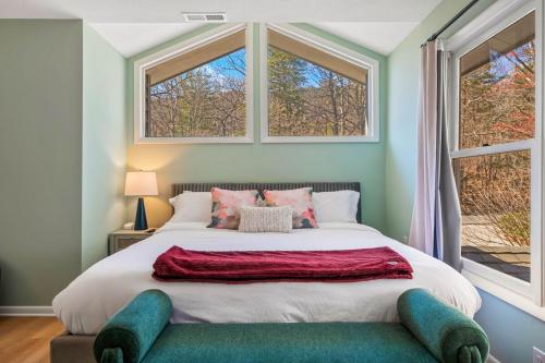 a bedroom with a large bed with two windows at Pet Friendly, Mini Golf, Game Room, Hot Tub in McGaheysville