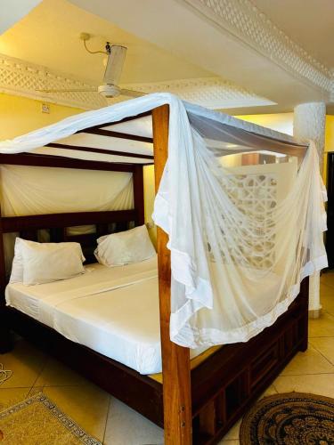 a bedroom with a bunk bed with a mosquito net at Jean pierre studio apartment in Malindi