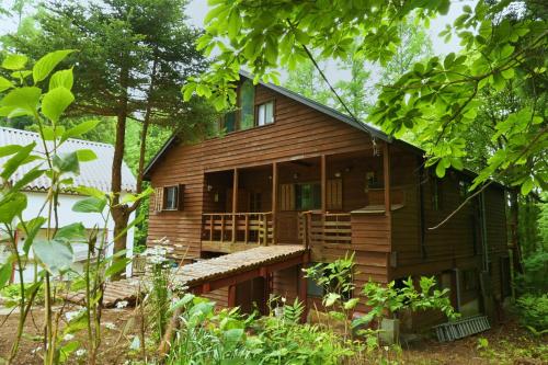 a wooden house in the middle of a forest at Warm Spacious Forest Chalet & Private Onsen in Minakami