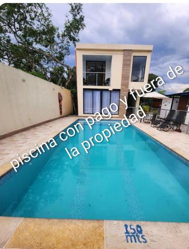 a swimming pool in front of a house at Elegante, hermoso, equipado en Villeta in Villeta