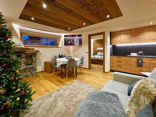 a living room with a christmas tree and a bedroom at Bait da Diego in Livigno