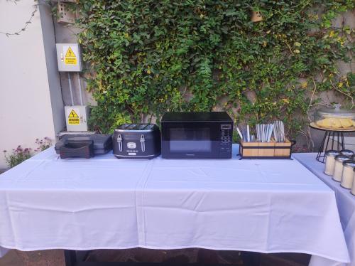 Una mesa con un mantel blanco con un microondas encima. en Hotel Terra by Refugio Ecológico, en Arequipa