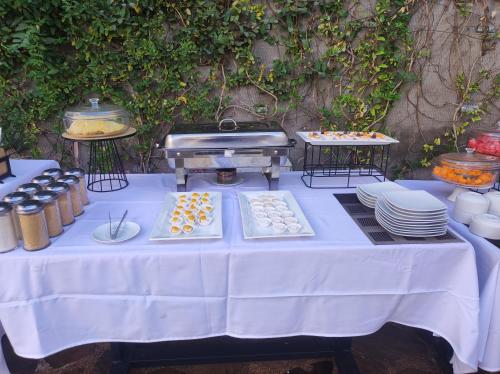 Una mesa con platos y una parrilla con comida encima. en Hotel Terra by Refugio Ecológico, en Arequipa