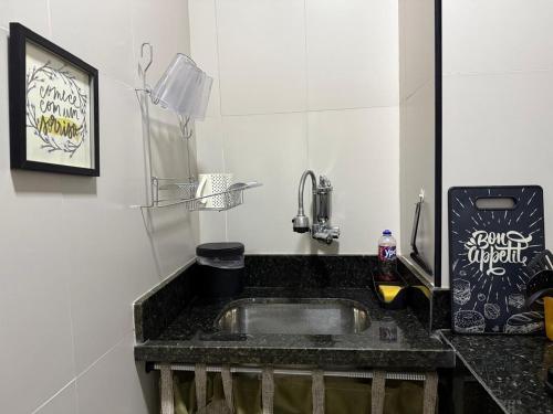 a kitchen with a sink and a black counter top at Apartamento Aconchegante em Botafogo in Rio de Janeiro