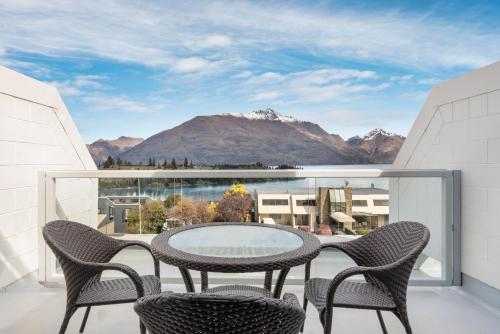a balcony with a table and chairs and mountains at Copthorne Hotel & Apartments Queenstown Lakeview in Queenstown