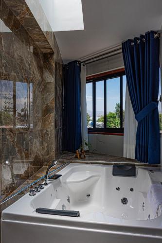 a large white tub in a bathroom with a window at Hotel Terra in Arequipa