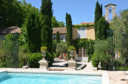 a house with a swimming pool in front of a house at La Banastiere in Vedène