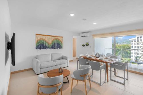 a living room with a table and chairs and a couch at Upstay Brand New 3BR Viva Jaco Residences in Jacó