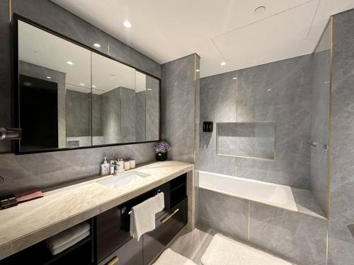 une salle de bain avec une baignoire, un lavabo et un miroir dans l'établissement เพ้นท์เฮ้าส์ Boulevard - Point Downtown Dubai, à Dubaï