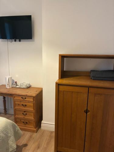 a bedroom with a bed and a dresser and a tv at 4 Bayview terrace in Bundoran