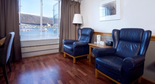 a room with two chairs and a table and a window at Home Hotel With in Tromsø