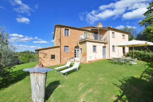 a large house with a yard with chairs and tables at Fontesecca - Happy Rentals in Città della Pieve
