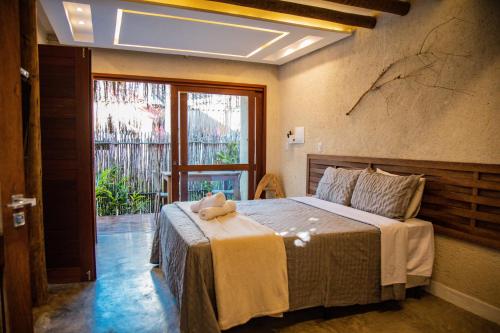 a bedroom with a bed with a teddy bear on it at Naim Milagres in São Miguel dos Milagres