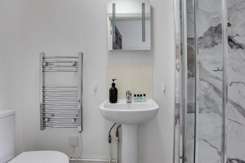 a white bathroom with a sink and a shower at NOW OPEN! Brand new rooms City Centre Modern Ensuite Rooms by Luxiety Stays in Cambridge