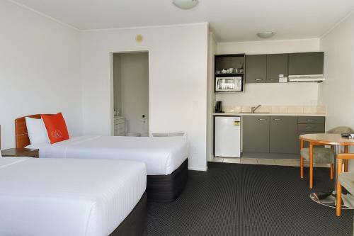 a hotel room with two beds and a kitchen at Ascot Motor Lodge in Wellington