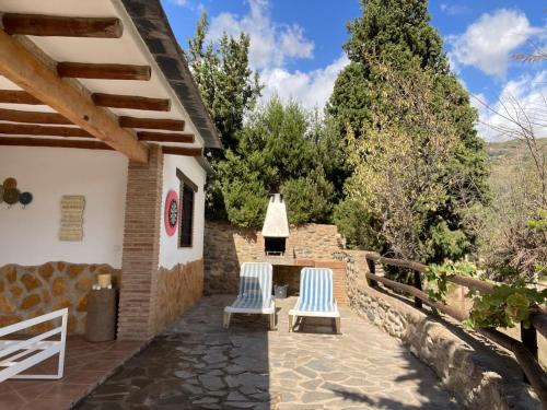 a patio with two chairs and a house at Beautiful villa in a Peaceful Haven in Órgiva