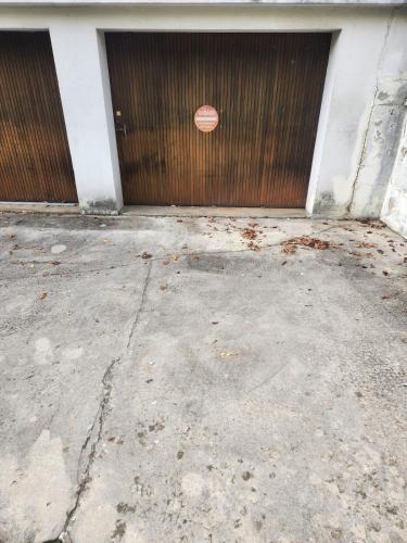 une porte de garage avec un panneau rouge dessus dans l'établissement La Chambre de Sophie - Studio et garage au calme, proche centre ville, à Lons-le-Saunier