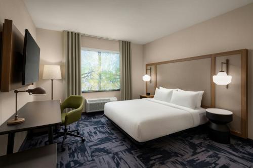 a hotel room with a large white bed and a desk at Fairfield Inn & Suites by Marriott Chilliwack in Chilliwack