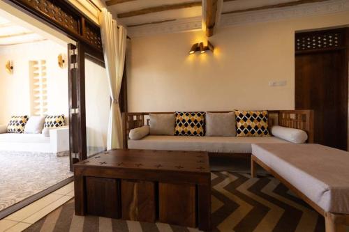 a room with a bed and a couch and a table at Munje Luxury Beach Villas in Msambweni