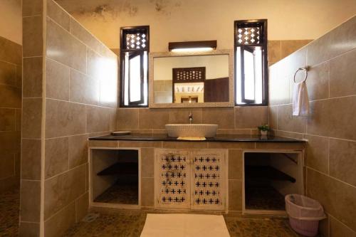 a bathroom with a sink and a mirror at Munje Luxury Beach Villas in Msambweni