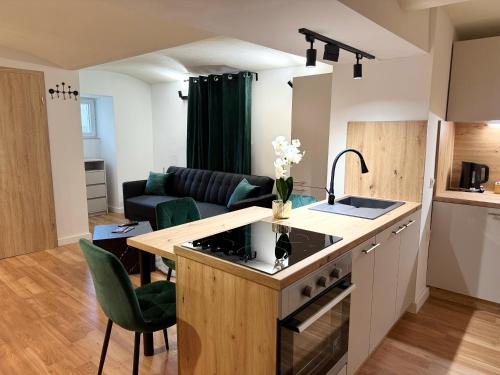 a kitchen and a living room with a couch at URBAN BASE CELJE Apartment with FREE Parking & Terrace in Celje